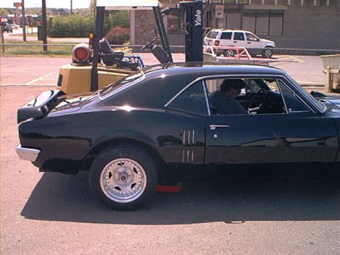 1978 Ford Bronco - Side view of a black coupe with a spoiler, likely a 1967 model.