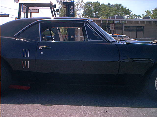 Black 1968 Pontiac Firebird coupe, side view. Three vertical vents on the front fender