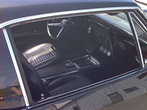 1978 Ford Bronco - The interior of a classic car features a black dashboard with three gauges and a chrome shifter on the center console.