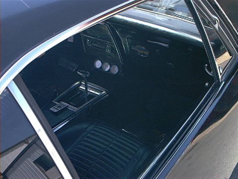 1978 Ford Bronco - The interior of a classic car shows a floor shifter, three gauges, and a remote control on the center console.