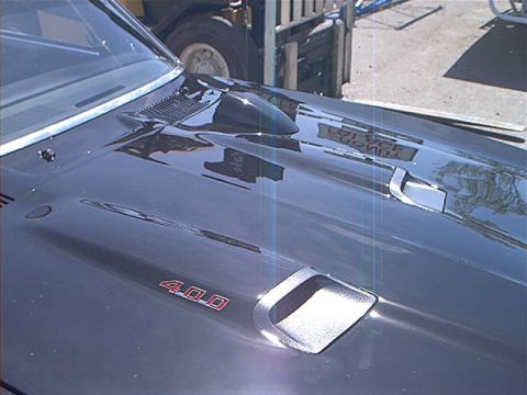 1978 Ford Bronco - The hood of a classic car features a prominent scoop and a '400' badge, indicating its engine size.