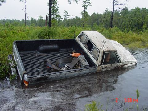 1995 Dodge 1500 - A truck is stuck in water, with most of its front end submerged in the murky depths.