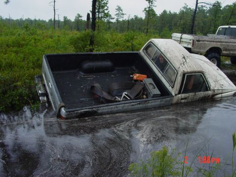 1995 Dodge 1500 - A truck is partially submerged in water, with another truck visible in the background.