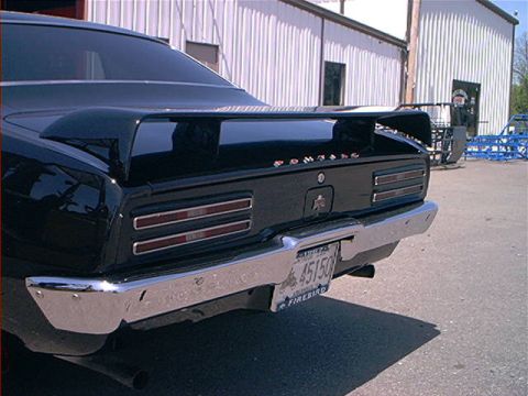 1978 Ford Bronco - Rear view of a black car with a spoiler and chrome bumper, displaying a license plate that says 45150 FIREBIRD.
