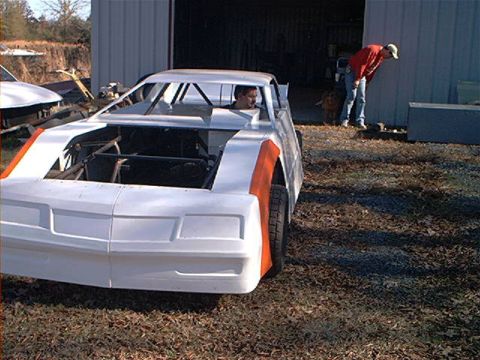 1978 Ford Bronco - A partially completed race car sits outside a garage, awaiting further modifications.