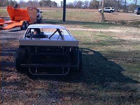 1978 Ford Bronco - A modified car with a roll cage sits in a grassy area, appearing to be a project vehicle.