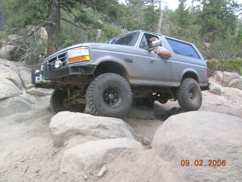 1985 Ford Bronco - This Ford Bronco is navigating a challenging rocky terrain on an off-road trail.