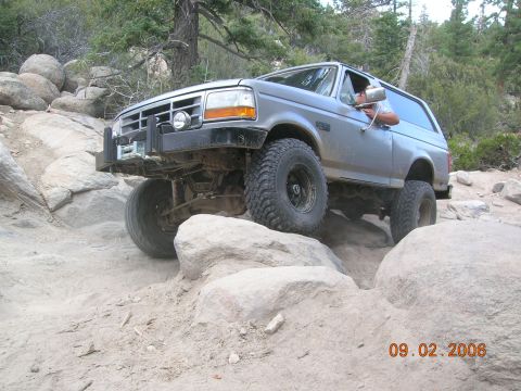 1985 Ford Bronco - This Ford Bronco navigates a rocky trail, demonstrating its off-road capabilities.