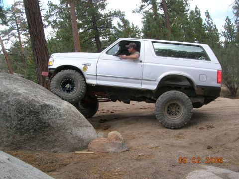 1985 Ford Bronco - A white 1992 Ford Bronco navigates a rocky off-road course.