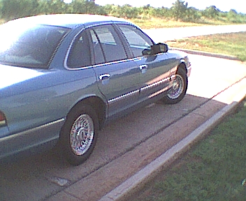 1994 Ford Crown Victoria - Side view of a blue 1994 Ford Crown Victoria parked on a paved surface.