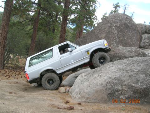 1985 Ford Bronco - Ford Bronco navigating a rocky off-road course. The vehicle appears to be from the early 1990s.