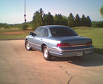 1994 Ford Crown Victoria - Rear view of a blue sedan with a visible license plate and a watermark at the bottom right.