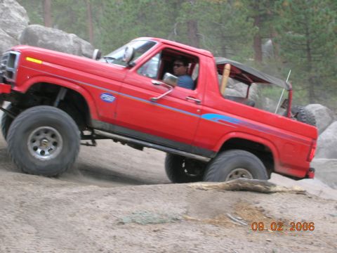 1985 Ford Bronco - This red 1985 Ford Bronco is navigating a rocky, off-road course.