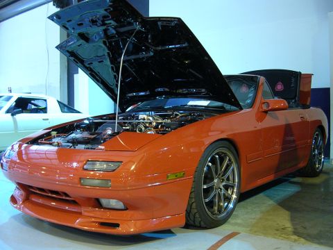 1996 Ford Probe - This orange convertible has its hood and trunk open, revealing the engine and rear storage area.