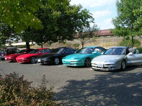 1996 Ford Probe - A row of Ford Probes are parked in a lot on a sunny day.