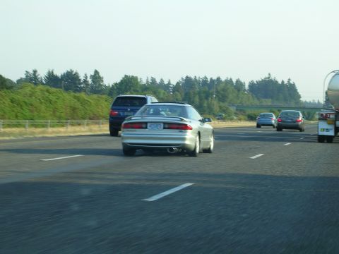 1996 Ford Probe - A silver 1996 Ford Probe travels down a highway with other vehicles on the road.