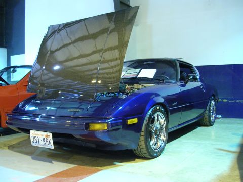 1996 Ford Probe - A blue Mazda RX-7 is displayed with its hood open, revealing the engine bay.
