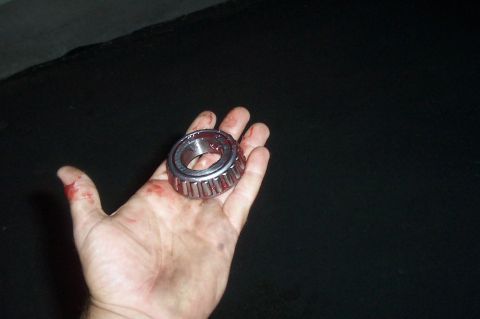 1994 Ford F-150 - A wheel bearing is shown in a hand with blood on the fingers.
