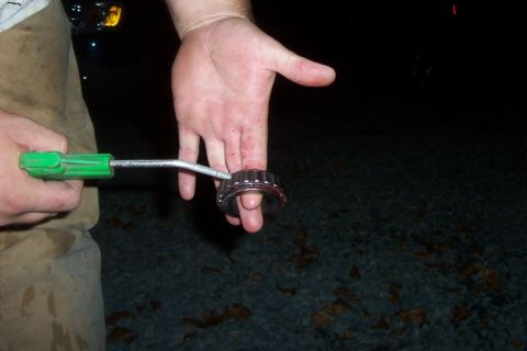 1994 Ford F-150 - A hand holds a wheel bearing, possibly for removal or installation, with a tool nearby.