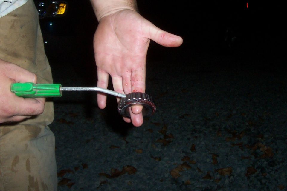 Hand holding a wheel bearing with a tool