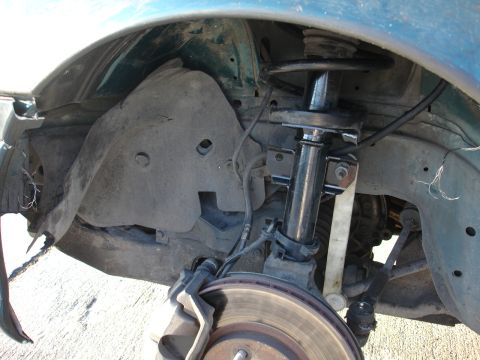 1995 Ford Taurus - The front suspension and brake components of a vehicle are visible in this close-up shot.
