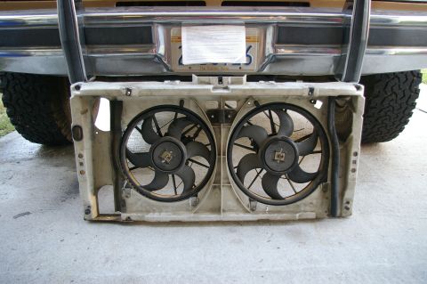 1986 Ford Bronco - A dual electric fan assembly is shown removed from a vehicle, with the rear bumper and tires visible above.