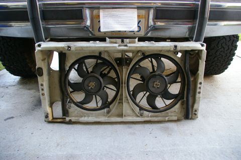 1986 Ford Bronco - Dual electric fans are shown removed from the front of a vehicle, with the rear bumper and license plate visible in the background.
