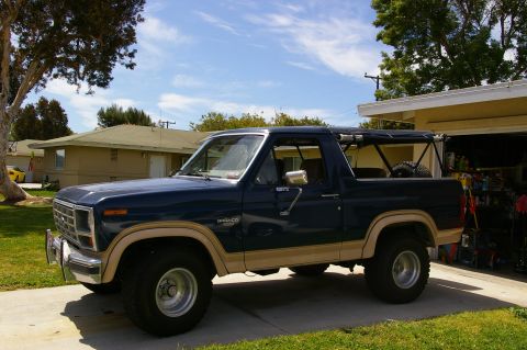 1986 Ford Bronco - This Ford Bronco is parked in front of a suburban house and garage on a sunny day.