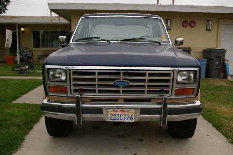 1986 Ford Bronco - Front view of a 1986 Ford Bronco parked in a driveway in front of a house.