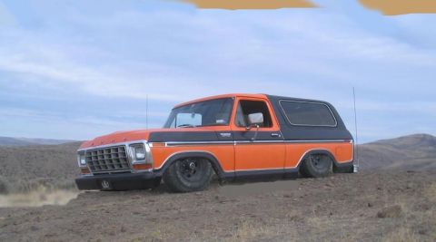 1979 Ford Bronco - This two-tone Ford Bronco sits low on a dusty, arid landscape under a cloudy sky.