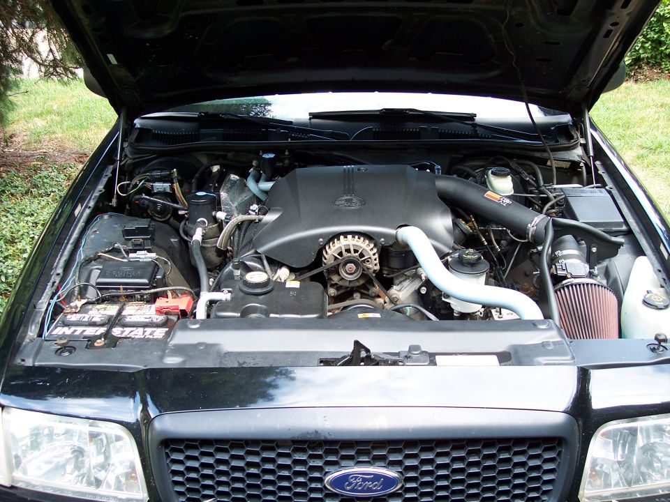 Engine bay of black Ford Crown Victoria with K&N cone air intake and Interstate battery