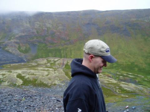 2000 Ford E350 - Man in a hat and hoodie with a mountainous landscape in the background. Supermotors.net logo visible.