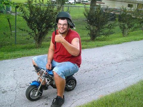 1986 Ford Bronco - Man on a mini bike on a paved road.