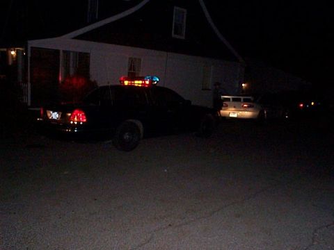 1991 Ford Crown Victoria - A 1991 Ford Crown Victoria police car is seen from the rear at night, with another vehicle visible in the background.