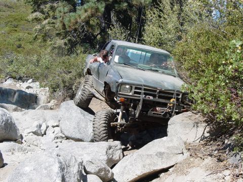 1986 Ford Bronco - This modified truck navigates a challenging rocky trail, its off-road capabilities.