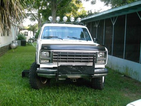 1986 Ford Bronco - This lifted pickup truck features a prominent grille and auxiliary lighting mounted above the windshield.
