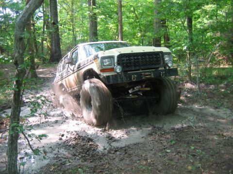 1992 Ford Mustang - This heavily modified 4x4 is navigating a muddy trail in the woods.