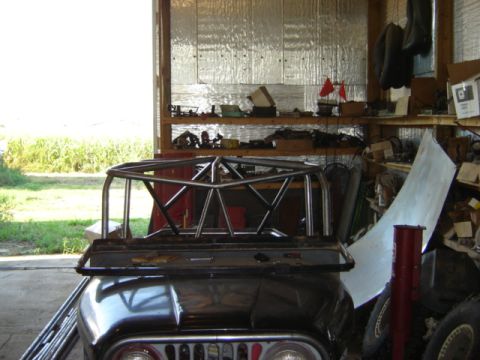 1992 Ford Bronco - Roll cage assembly is being worked on inside a garage.