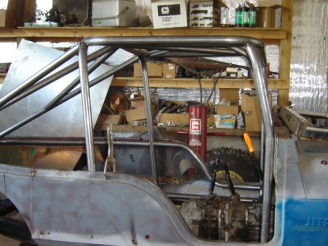 1992 Ford Bronco - Custom roll cage fitted to a vehicle's interior, with visible drivetrain and unfinished body panels.