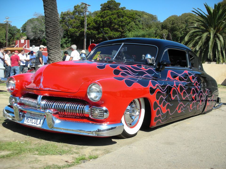 Red and black flamed chopped Mercury lead sled custom at a car show