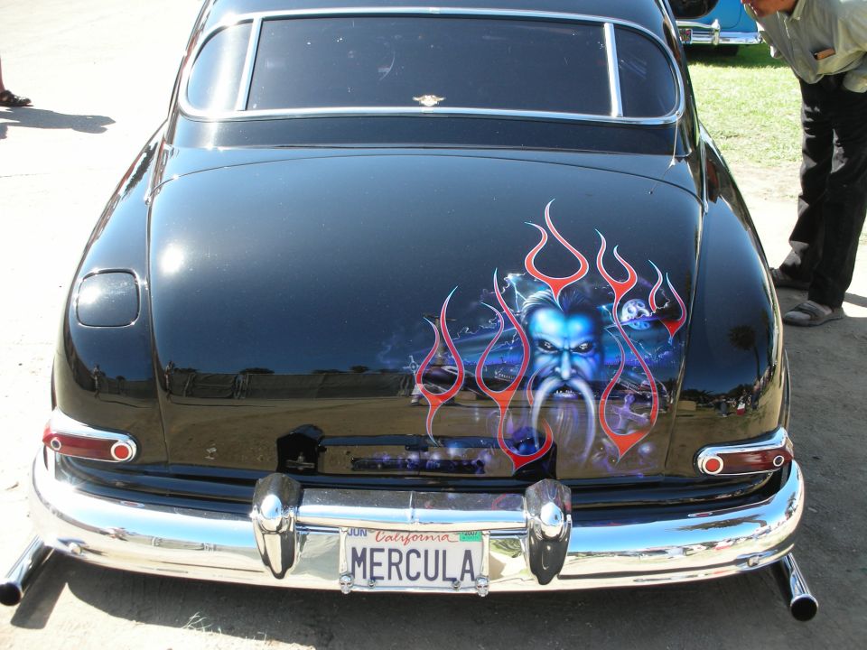 Trunk airbrush of a blue ghoul face in flames on a black custom car
