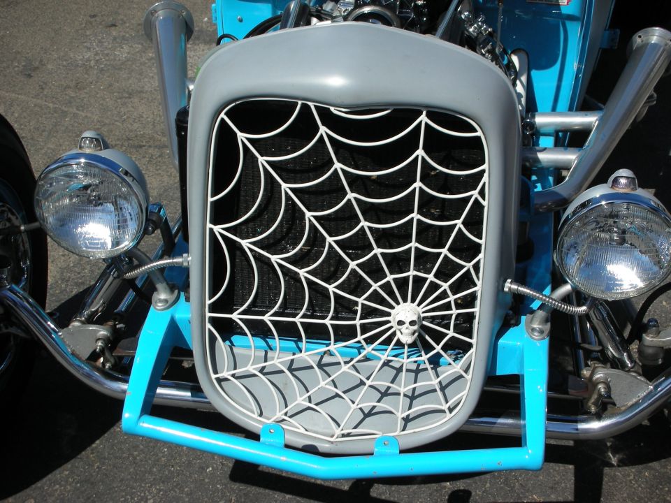 Spiderweb grille with skull on a blue hot rod's front end
