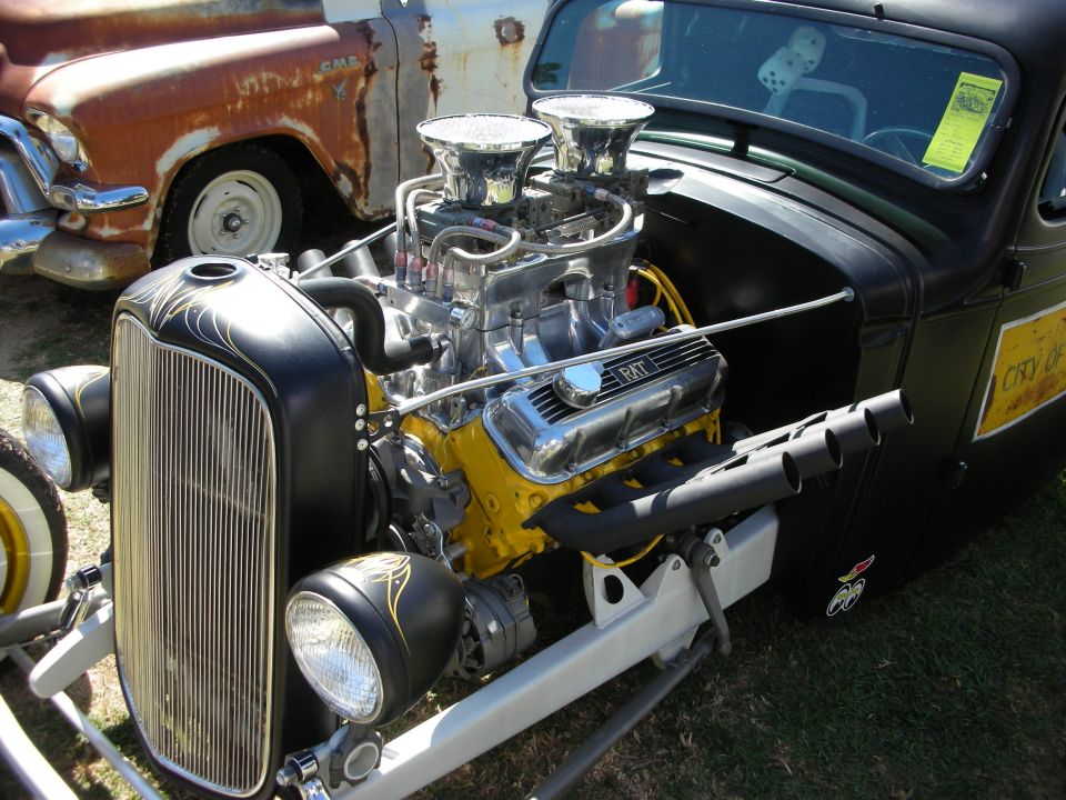 Black hot rod pickup with chrome dual-carb engine and pinstriped grille