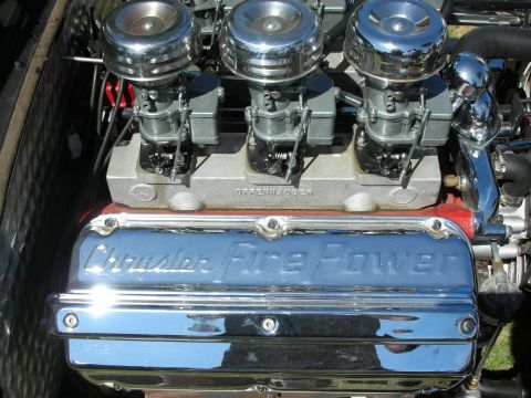 1998 Ford Crown Victoria - polished Chrysler FirePower hemi valve cover next to three round chrome air-cleaner carburetors on an engine.