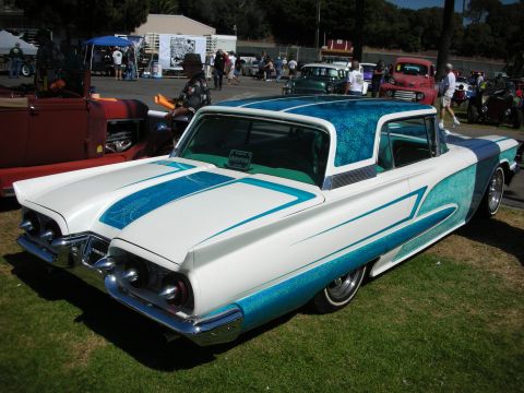 1998 Ford Crown Victoria - white custom coupe with teal metalflake side scallops and roof panel, scalloped pinstriping and whitewall tires, shown rear three-quarter a…