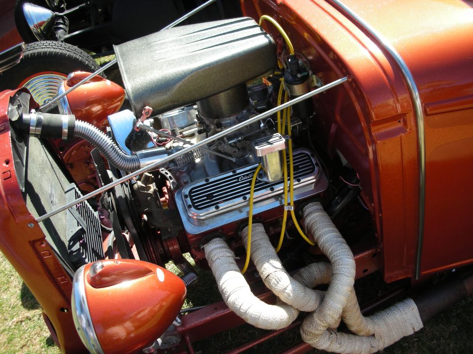 Copper-orange hot rod engine bay with chrome V8 and wrapped exhaust headers