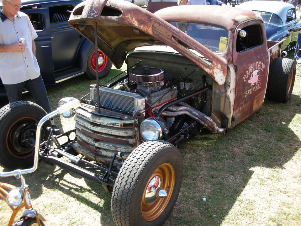 Rusty patina rat rod pickup with chrome V8 and 'Pork Chop Special' lettering