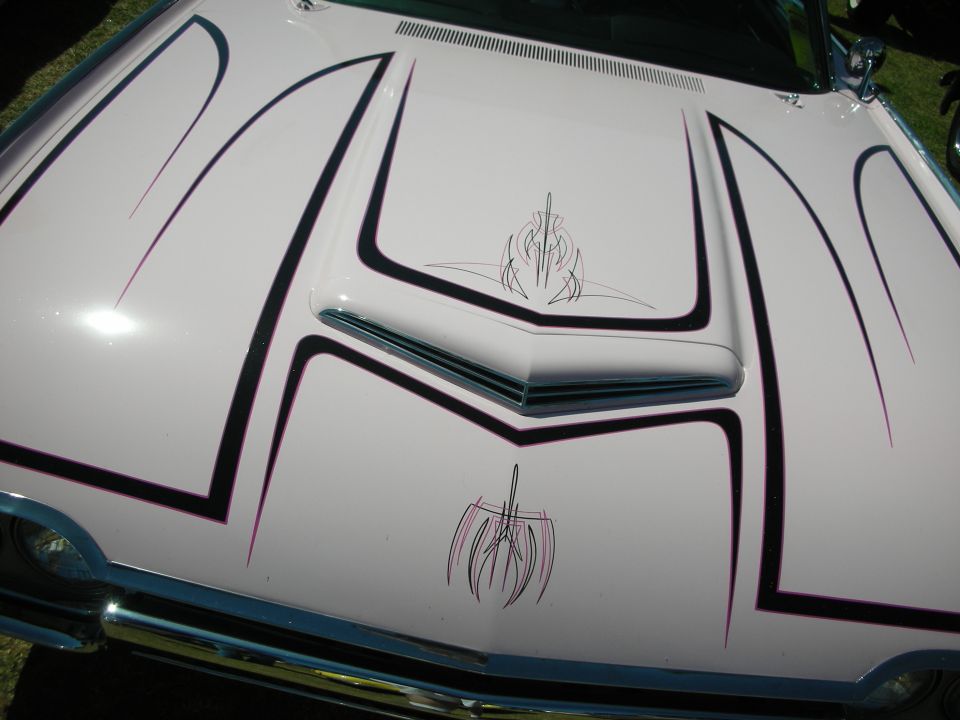 White custom hood with black and pink pinstriping and a scoop