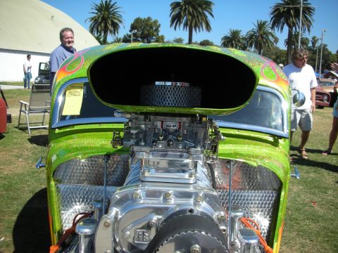 1998 Ford Crown Victoria - Front view of a candy-green metalflake custom hot rod with its hood open, showing a polished blower, dual carbs and a finned air cleaner at…
