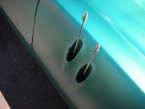 1998 Ford Crown Victoria - Detail of a teal custom car body panel with two oval recessed scallops accented by slim pointed chrome spear trim.